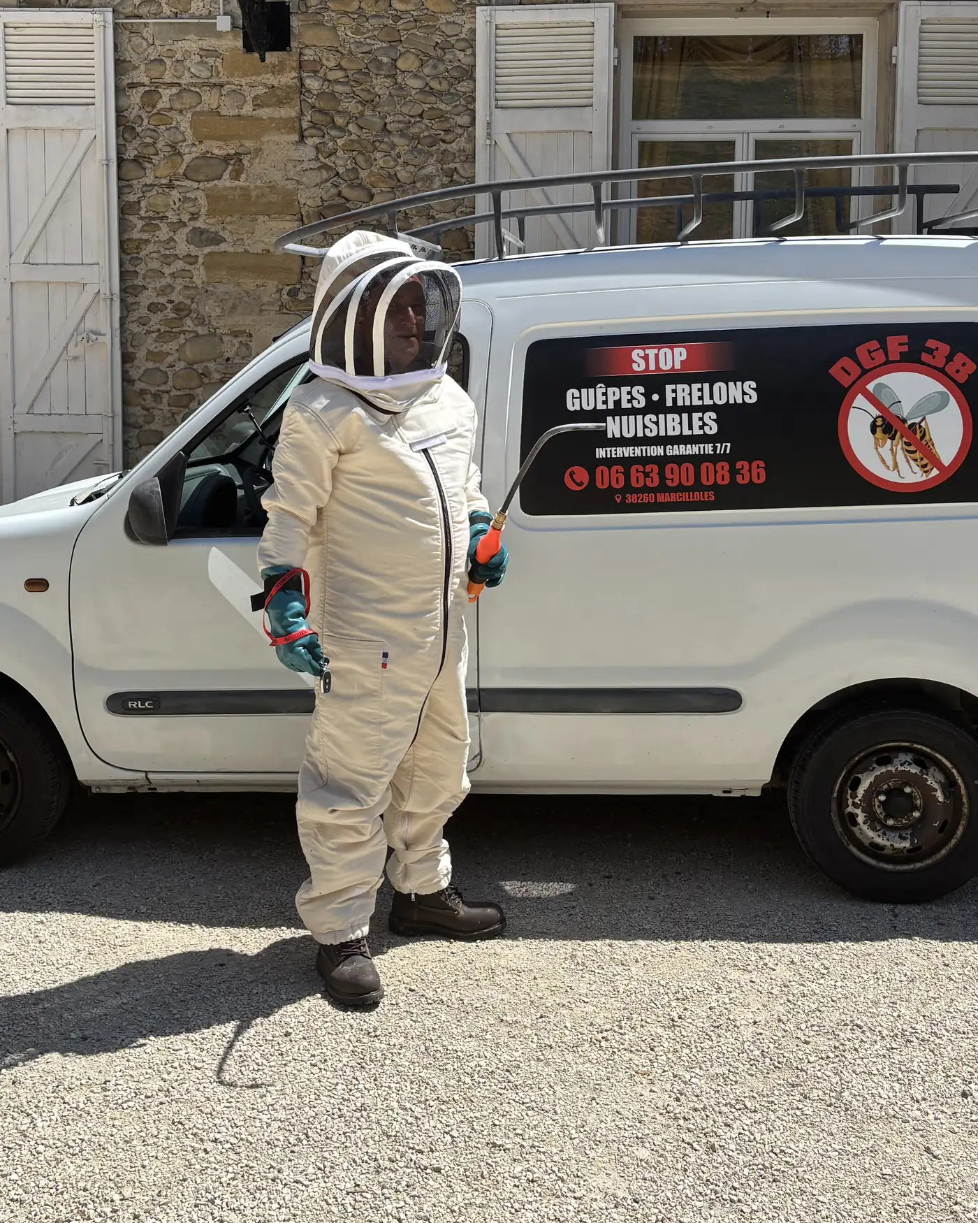 Technicien DGF 38 en combinaison de protection intégrale devant le véhicule d'intervention
