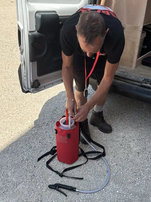 Préparation du pulvérisateur dorsal à l'arrière du véhicule d'intervention